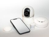 Collection of smart home security gadgets with a smartphone display.