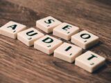 Scrabble tiles spelling SEO Audit on wooden surface, symbolizing digital marketing strategies.