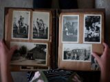 person opening photo album displaying grayscale photos