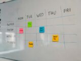a white board with sticky notes attached to it
