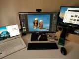 Photographer's workspace with dual monitors, laptop, and editing software.