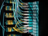 Closeup of switch in server with connectors and adapters connected to plastic device in dark room on blurred background inside