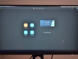 Contemporary stationary black rectangular monitor showing time on display with wires placed on brown background at convenient workplace in room