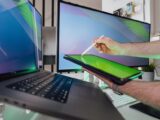 A person using a stylus on a tablet in a tech-savvy workspace with dual monitors