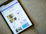 A tablet on a couch showing the Wallis.io website interface.