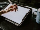 person holding white ipad with black case
